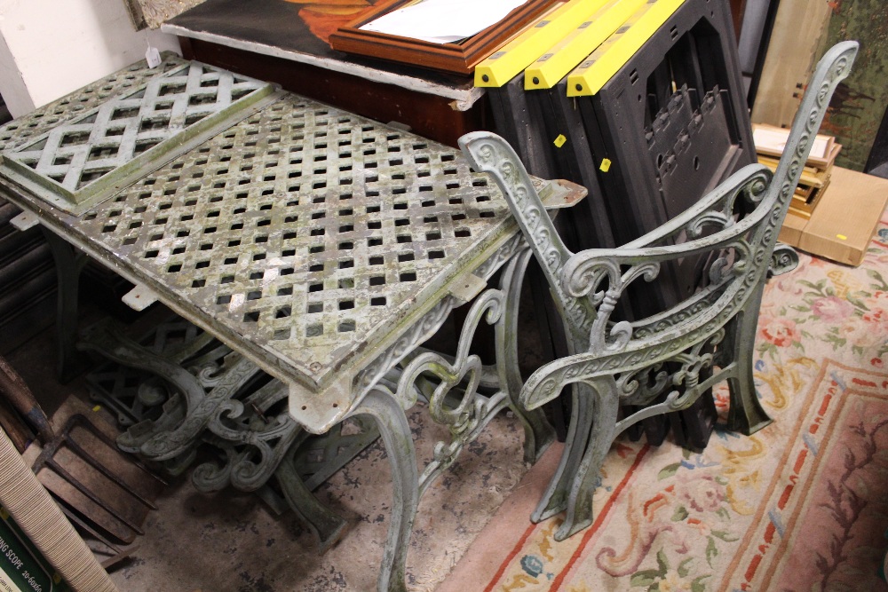 A CAST GARDEN TABLE, 3 PAIRS OF BENCH ENDS AND A BACK PIECE