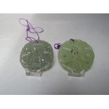 TWO CHINESE JADE CARVED AND PIERCED CIRCULAR PENDANTS, both with typical pierced carved