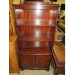 A REPRODUCTION MAHOGANY OPEN WATERFALL BOOKCASE WITH A TWIN DOOR CUPBOARD BELOW H-149 W-70 CM