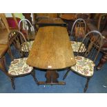 AN OAK DECORATIVE TABLE WITH FOUR ERCOL STYLE CHAIRS