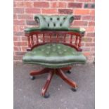 A REPRODUCTION GREEN LEATHER SWIVEL ARMCHAIR - DAMAGE TO ARMS