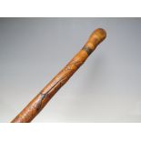 A VINTAGE ORIENTAL CARVED WAKING CANE WITH ROOT BALL KNOP, the shaft having typical carved