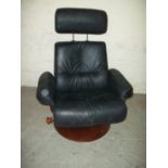 A LARGE BLACK LEATHER SWIVEL RECLINING CHAIR WITH ADJUSTABLE HEADREST