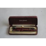 A CONWAY STEWART BOXED SET, A UNIVERSAL 479 FOUNTAIN PEN AND MATCHING PENCIL, in red marble finish