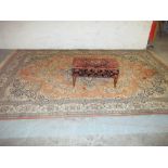 A LARGE RUG AND AN ANTIQUE FOOTSTOOL