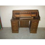 AN ANTIQUE TWIN PEDESTAL ROLL TOP DESK