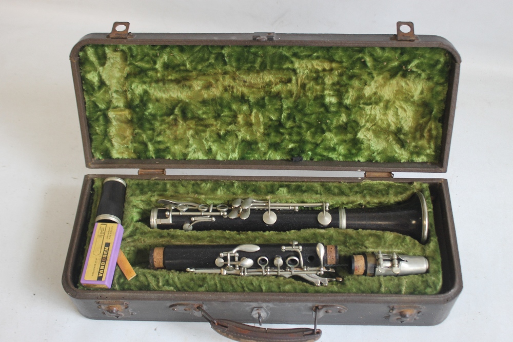 A CASED F. BUISSON B FLAT CLARINET, with cleaner and spare reeds, plate on case reads "John E.