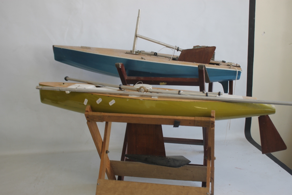 A PAIR OF VINTAGE FIBRE GLASS AND WOOD YACHTS AND STANDS, both 90 cm long