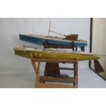 A PAIR OF VINTAGE FIBRE GLASS AND WOOD YACHTS AND STANDS, both 90 cm long