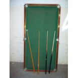 A TABLE TOP SNOOKER TABLE WITH CUES