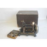 A VICTORIAN CAST SEWING MACHINE, black painted with gilt decoration, raised on four scroll feet in