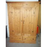 A TWO DOOR, TWO DRAWER SOLID PINE WARDROBE