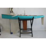 A LARGE VINTAGE FIBRE GLASS AND WOOD YACHT AND STAND, 160 cm long with sail