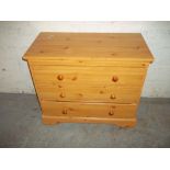 A THREE DRAWER CHEST OF DRAWERS