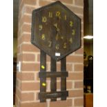 AN ARTS AND CRAFTS WOODEN WALL CLOCK WITH LACKING PENDULUM