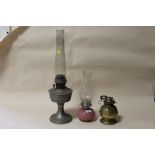 THREE ANTIQUE OIL LAMPS TO INCLUDE A PINK GLASS EXAMPLE