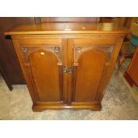 A SMALL REPRODUCTION OAK CD CABINET - H 91 CM, w 79 CM TOGETHER WITH A TWO TIER OAK TROLLEY (2)