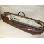 A VINTAGE LEATHER CRICKET BAG CONTAINING A PAIR OF CRICKET PADS AND A BALL