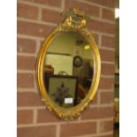 A CONTEMPORARY OVAL GILT WALL MIRROR - H 52 CM