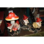 A GARDEN GNOME FIGURE GROUP TOGETHER WITH A TOADSTOOL