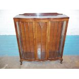 A VINTAGE SERPENTINE FRONTED CHINA DISPLAY CABINET (ONE CRACKED GLASS PANE)