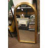 A MODERN GILT FRAMED ARCHED WALL MIRROR 41 CM X 89 CM