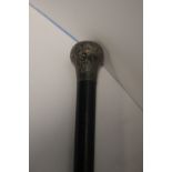 A WHITE METAL TOPPED EBONISED WALKING CANE