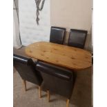 A SOLID PINE OVAL KITCHEN TABLE AND FOUR BROWN FAUX LEATHER CHAIRS