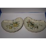 A PAIR OF BELLEEK KIDNEY SHAPED PLATES WITH DECORATIVE FLORAL DESIGN AND BLACK MARKS TO BASE