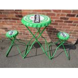 A MODERN 'HEINEKEN BEER' METAL FOLDING TABLE AND TWO STOOLS IN THE STYLE OF BOTTLE TOPS