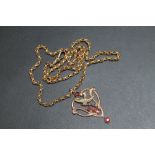 A 9CT GOLD EDWARDIAN STYLE GARNET SET PENDANT, upon an unmarked and untested yellow metal rollerball