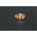 A HALLMARKED 18 CARAT GOLD RING, set with ruby style stones and diamond accents, approx weight 3.1g,