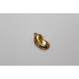 A 9CT GOLD BEAN SHAPED BRACELET CHARM (SPLIT TO ONE SIDE)