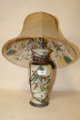 AN ORIENTAL TABLE LAMP WITH A DECORATIVE SHADE