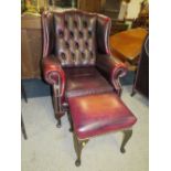 AN OXBLOOD RED LEATHER WINGBACK ARMCHAIR BY MARTIN BARNES LONDON TOGETHER WITH A STOOL