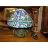 A TIFFANY STYLE TABLE LAMP WITH A BRONZED STYLE DOLPHIN BASE A/F H-38 CM (OVERALL)