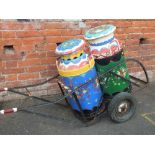 TWO PAINTED MILK CHURNS ON A TROLLEY - TROLLEY A/F