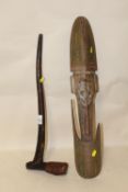 A PAPUA NEW GUINEA MASK AND A CARVED WOODEN AXE HANDLE