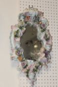A CONTINENTAL CERAMIC FRAMED WALL MIRROR WITH THREE CANDLE SCONCES - H 48 CM BY W 28 CM