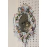 A CONTINENTAL CERAMIC FRAMED WALL MIRROR WITH THREE CANDLE SCONCES - H 48 CM BY W 28 CM