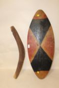 A LARGE ABORIGINAL CARVED PAINTED WOODEN SHIELD AND A BOOMERANG