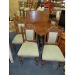 AN EDWARDIAN OAK EXTENDING DINING TABLE WITH ONE LEAF TOGETHER WITH FOUR CARVED OAK CHAIRS