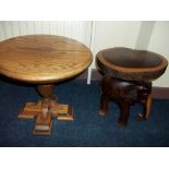 AN ADAM BECK TABLE AND A WOODEN ELEPHANT PLANT STAND