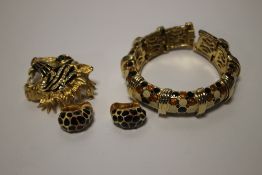 A BUTLER & WILSON TIGER'S HEAD BROOCH TOGETHER WITH A BANGLE AND A PAIR OF CLIP ON EARRINGS