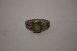 A 9 CT GOLD DRESS RING SET WITH A GREEN STONE