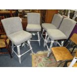 A SET OF FOUR UPHOLSTERED SWIVEL CHAIRS