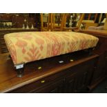 A LOW UPHOLSTERED FOOTSTOOL