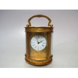 A MINIATURE ELLIOT AND SON BRASS OVAL CASED CARRIAGE CLOCK, the enamel dial with blue Roman numerals