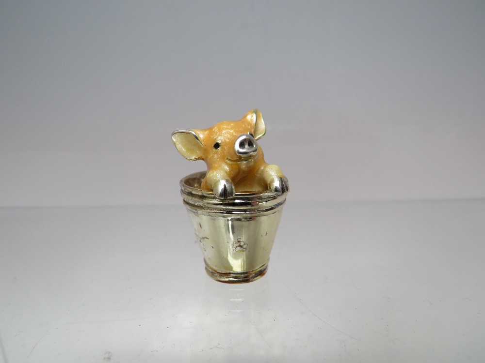 A MINIATURE SILVER AND ENAMEL PAINTED PIGLET IN A BUCKET, marks to base, H 3.5 cm