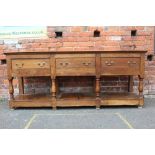 A 19TH CENTURY OAK DRESSER BASE, with three drawers, raised on thick turned supports, united by an